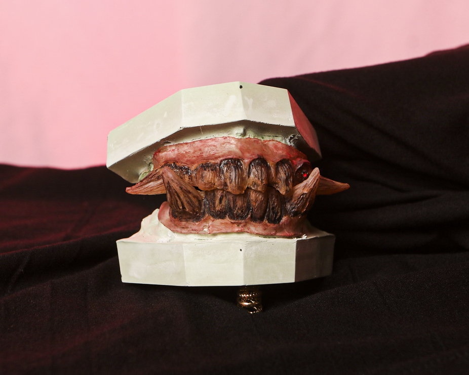 Teeth Chiara dark-fantasy creature teeth photographed against dramatic red and black fabric.
